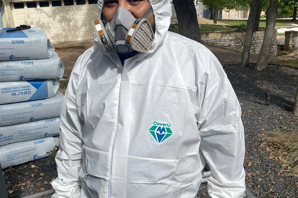 Air Central technician suited up for attic insulation job