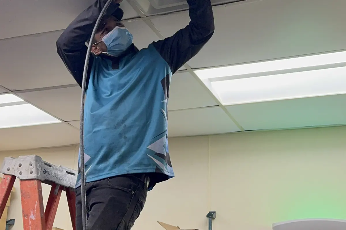 Commercial duct cleaning - technician servicing ceiling diffuser