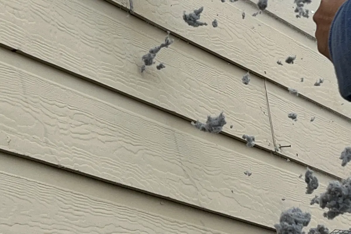 Lint blowing out of exterior vent during dryer vent cleaning