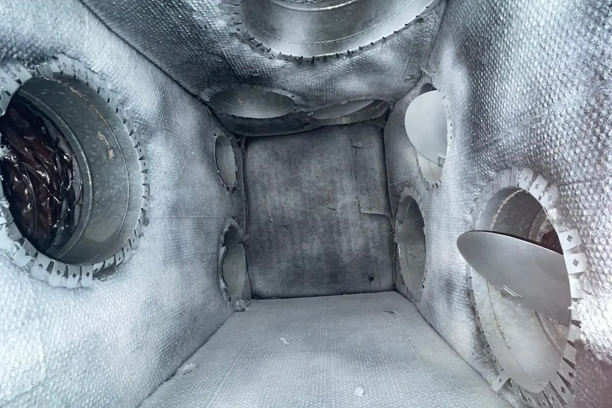 Clean plenum box interior showing multiple duct connections after service
