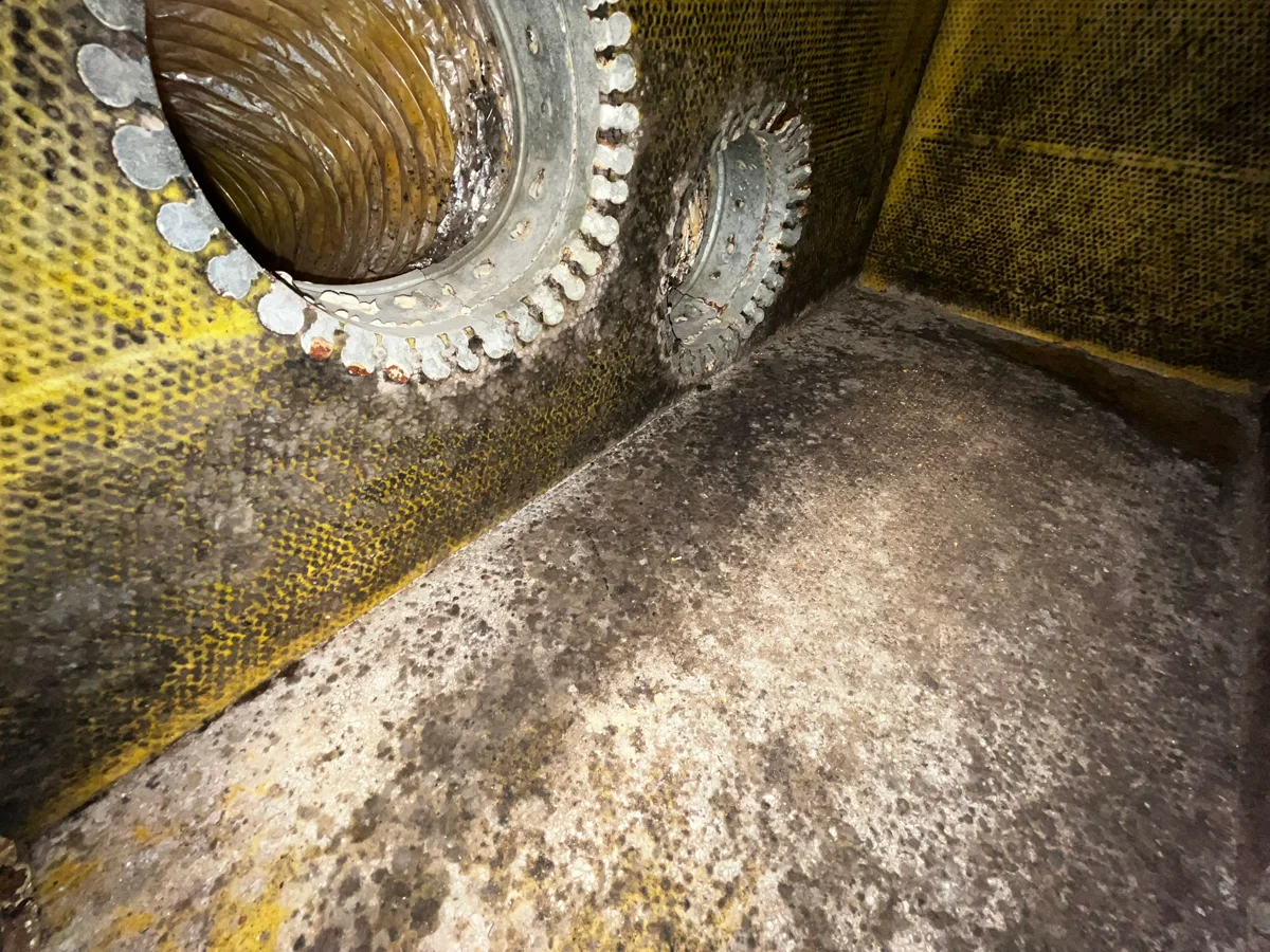 Plenum box interior during professional cleaning - before restoration